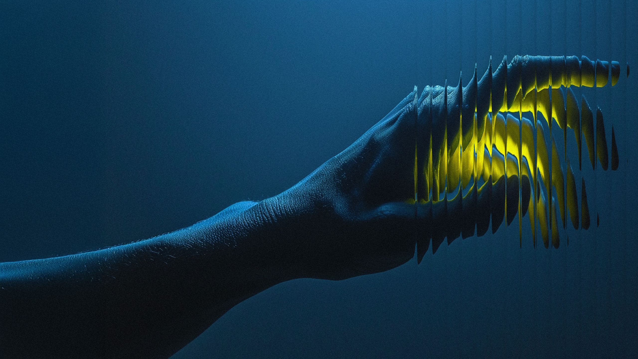 An outstretched arm and hand against a deep blue background, fragmented into vertical slices lit with yellow